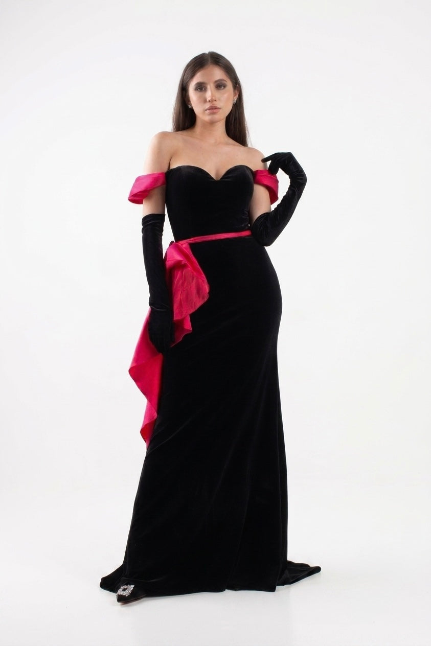 Vestido en velvet negro, escote corazon, corte sirena y diseño en fucsia mangas y costado de la cintura en renta