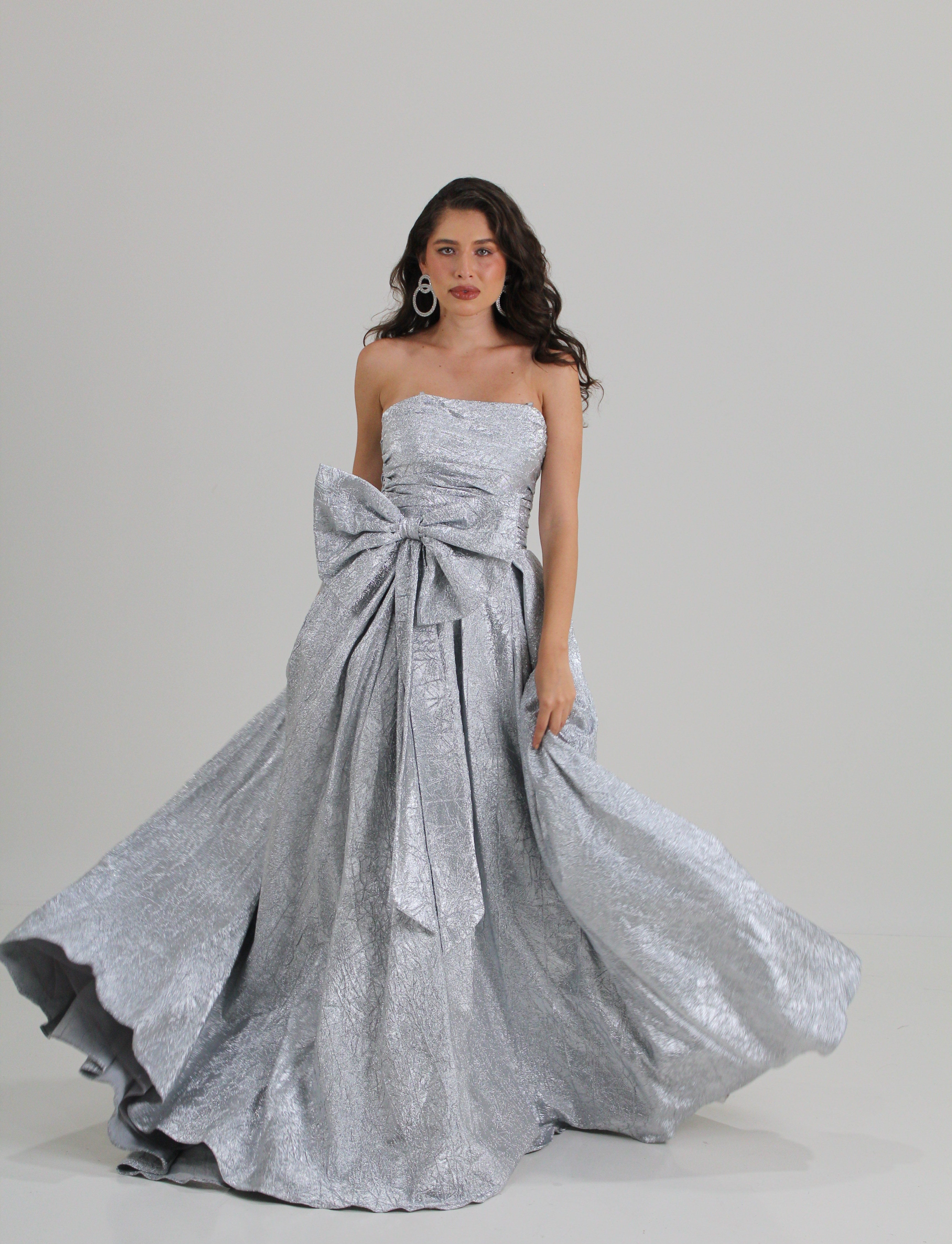 Vestido straple, color silver, corte princesa y diseño de moño en cintura en renta